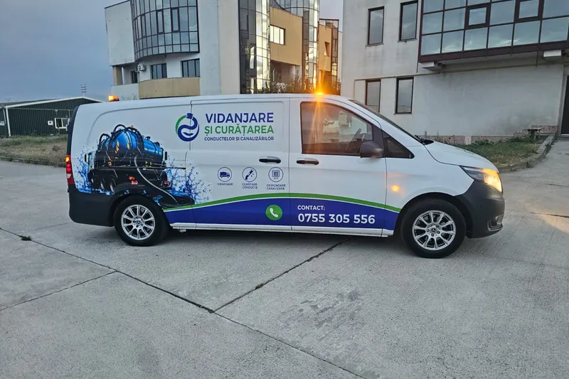 Autoutilitara albă de desfundare și curățare a conductelor, văzută din lateral